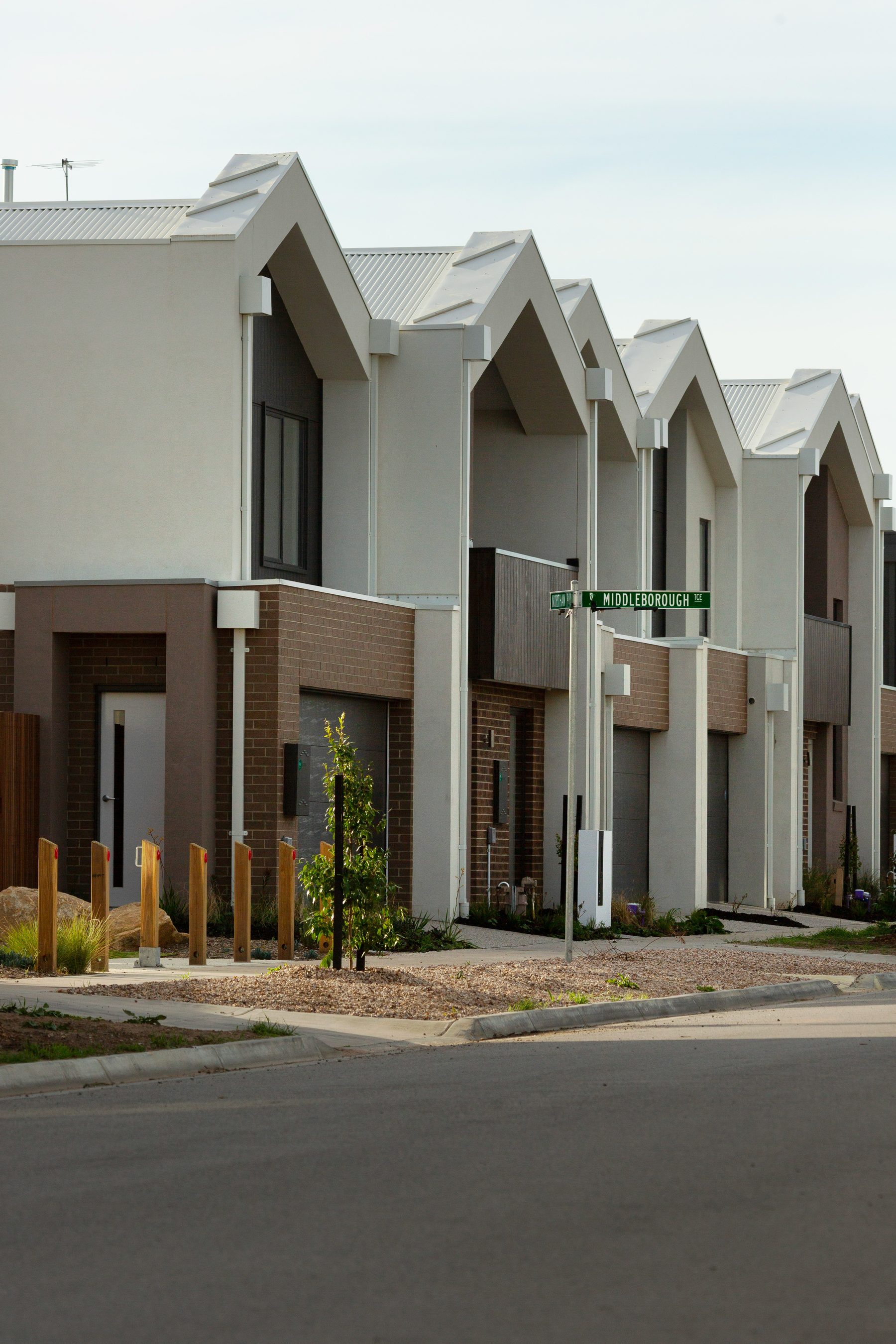 Row of new terrace-style townhouses in a Valenza Homes multi-unit development